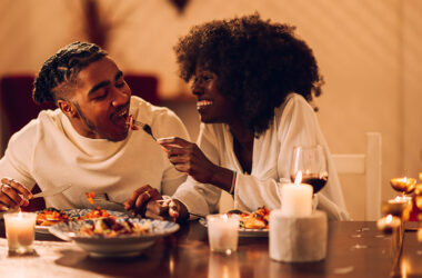 Eine Frau und ein Mann beim romantischen Candle-Light-Dinner, die ein Abendessen genießen.