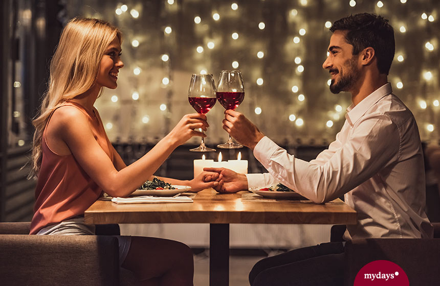 Paar stoßt bei einem Dinner mit Rotwein an