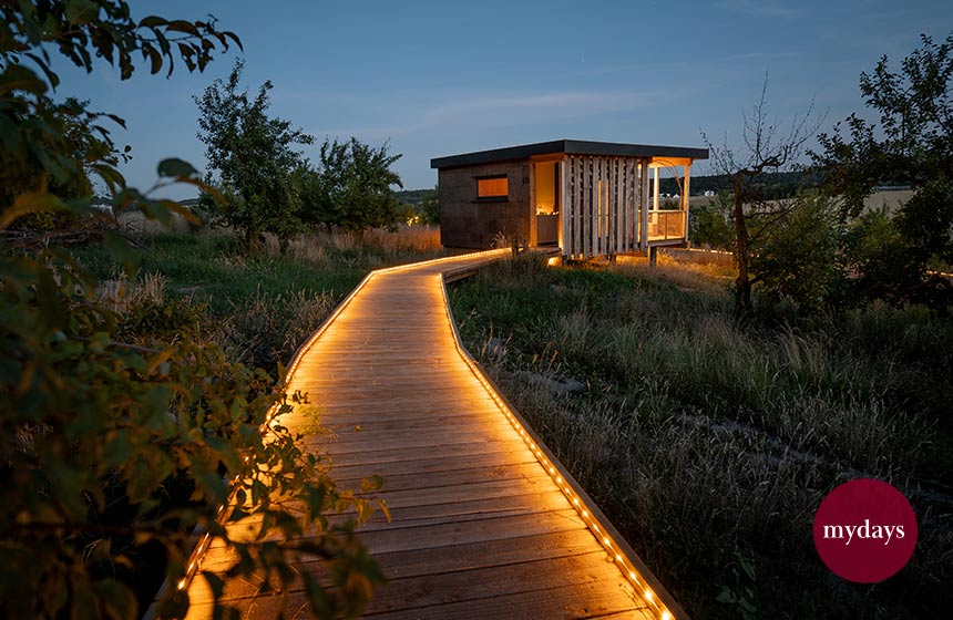 Ein Chalet bei Nacht mit beleuchtetem Weg