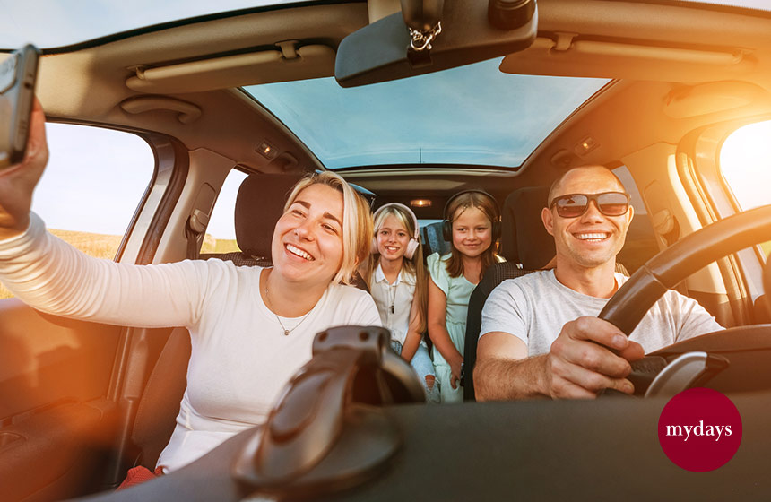 Familie sitzt in einem Auto bei einem Ausflug und ist gut gelaunt