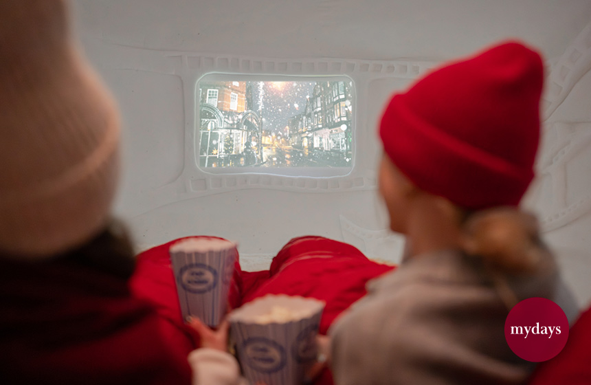Zwei Freundinnen schauen einen Film im Iglu