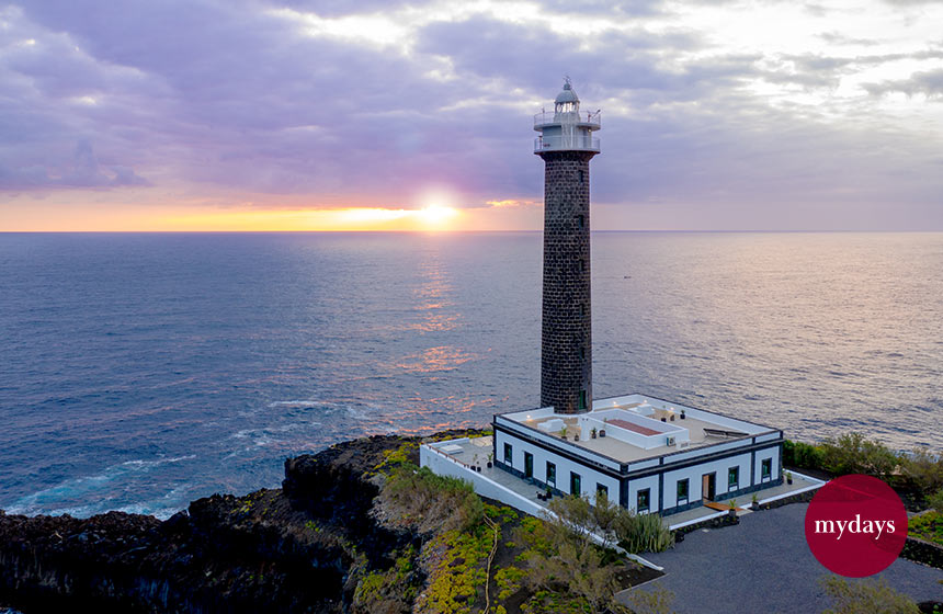 Ein Leuchtturm im Vordergrund mit dem Meer im Hintergrund
