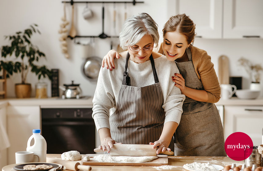 Mutter und Tochter stehen zusammen in der Küche und backen