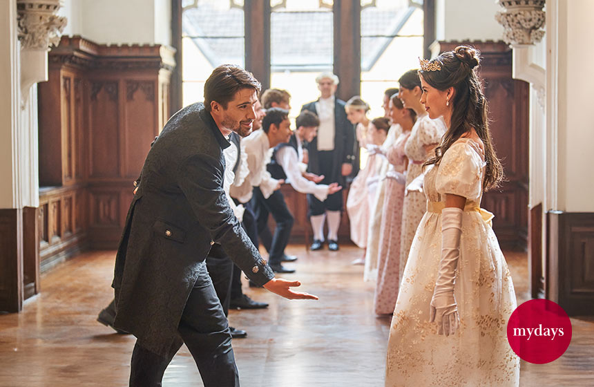 Ein Paar tanzt elegant gekleidet in einem großen Saal