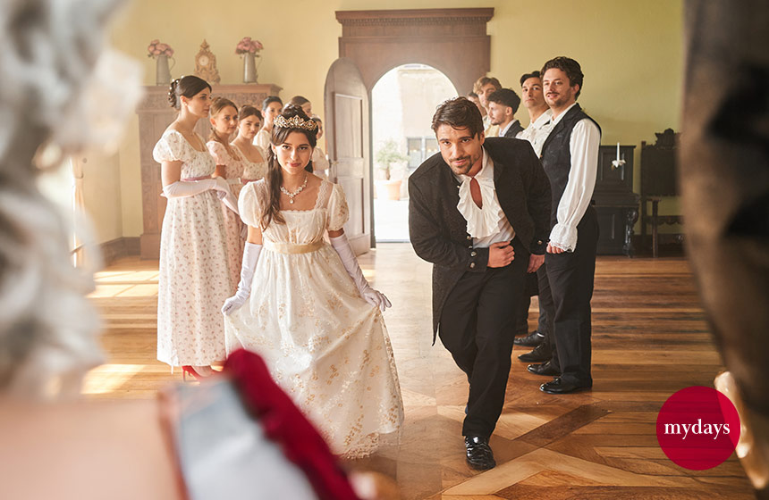 Zwei adlig gekleidete Menschen verbeugen sich vor der Königin