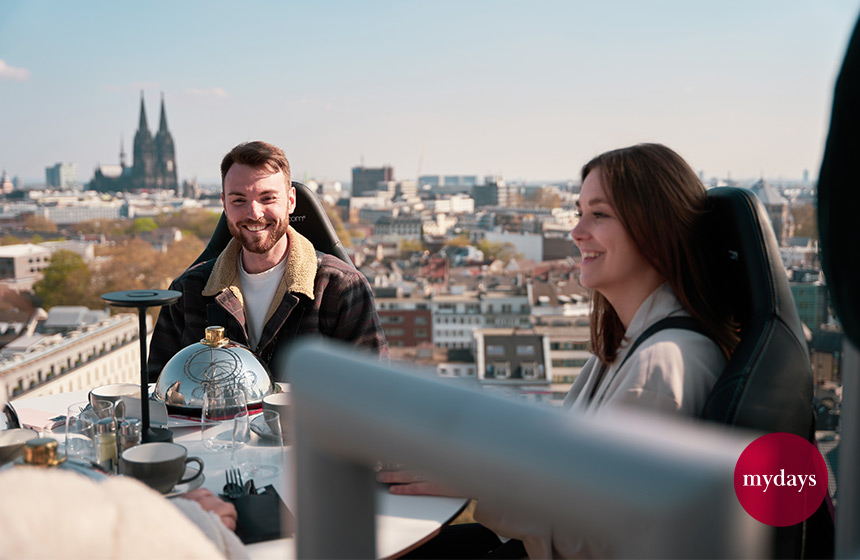 Zwei Menschen sind glücklich und lachen über den Dächern von Köln.