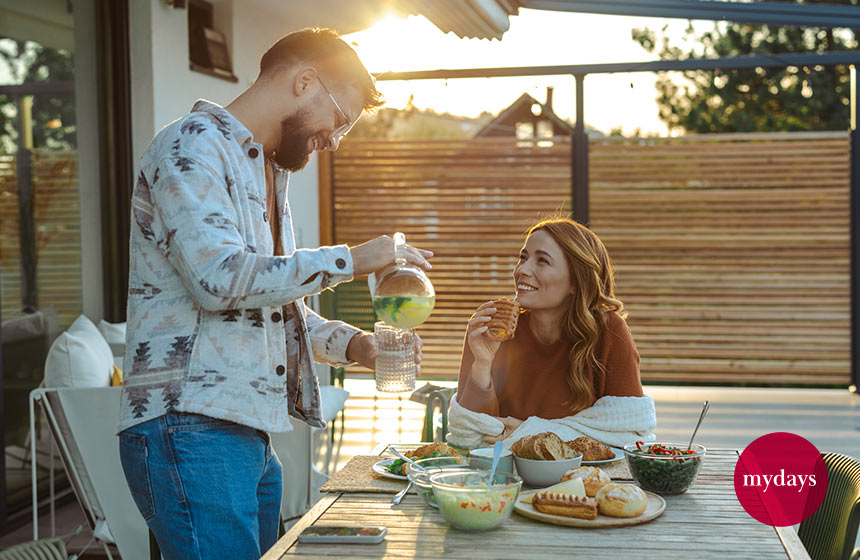 Zwei Personen essen ihr Frühstück am Tisch auf der Terrasse