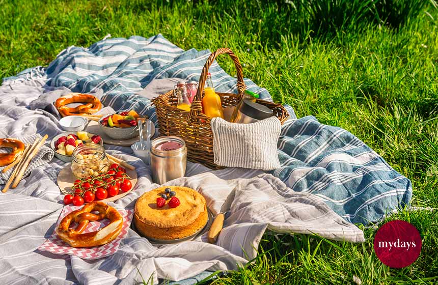 Picknickdecke mit Picknickkorb auf einer Wiese