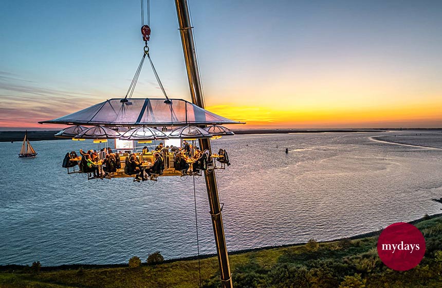 Dinner in the Sky bei Sonnenuntergang über dem Meer
