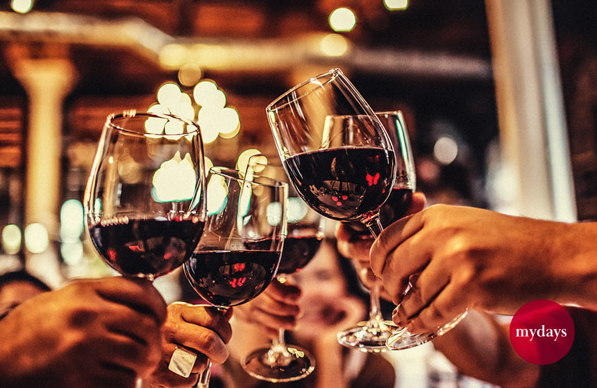Freunde stoßen mit Wein an.