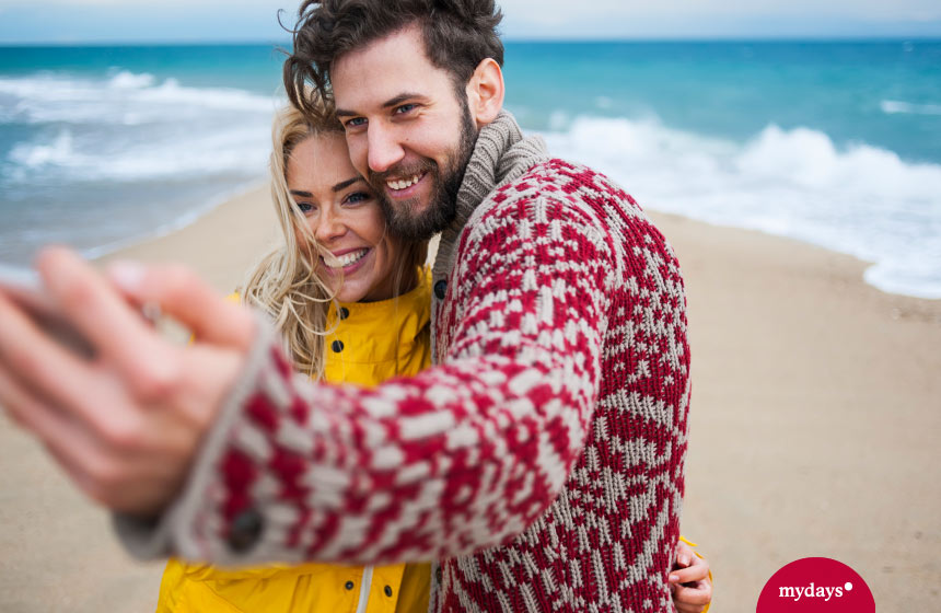 Pärchen macht ein Selfie am Strand