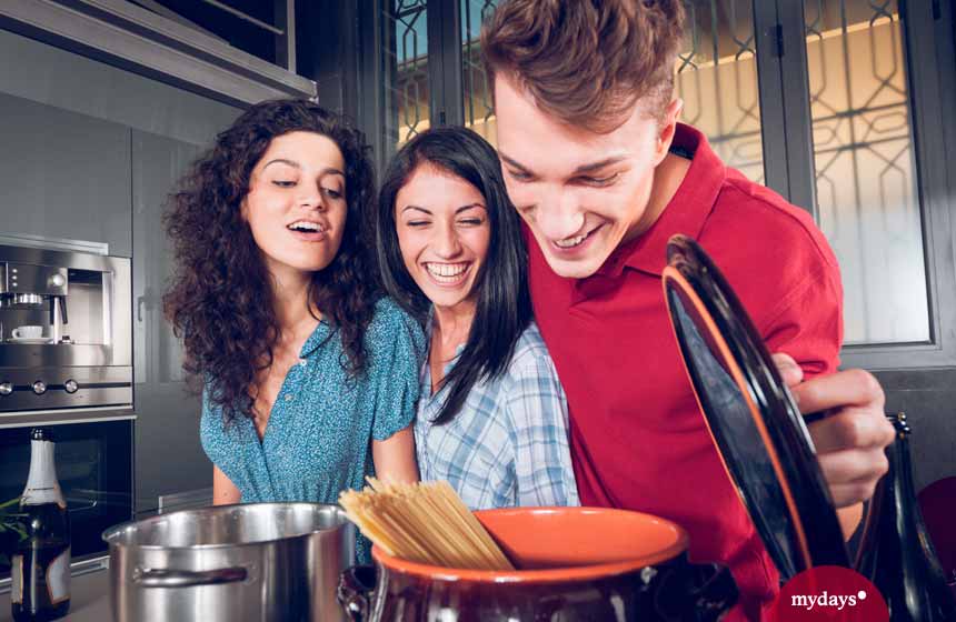 WG-Küche, Drei junge Leute beim Spaghetti kochen, zwei Frauen und ein Mann