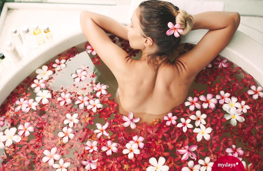 Frau badet im Blütenbad