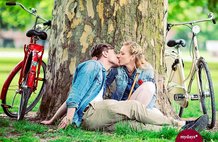 Ein Pärchen küsst sich in einem Park