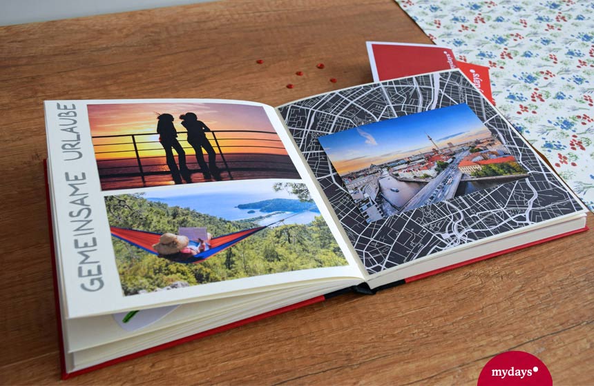 Buch mit Urlaubsfotos auf Holztisch