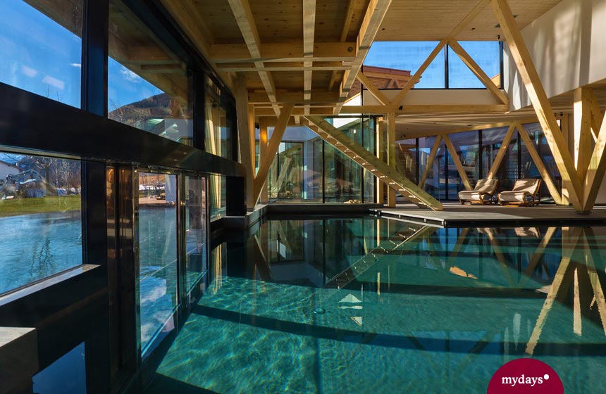 Luxuriöser Indoor und Outdoor Pool bei Sonnenschein in den Alpen