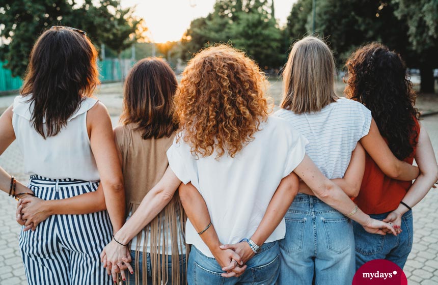 Fünf Freundinen in Rückenansicht halten Hände