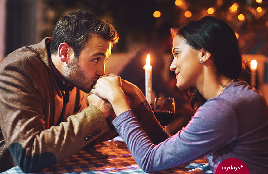 Paar beim Candle-Light-Dinner Mann küsst Hände