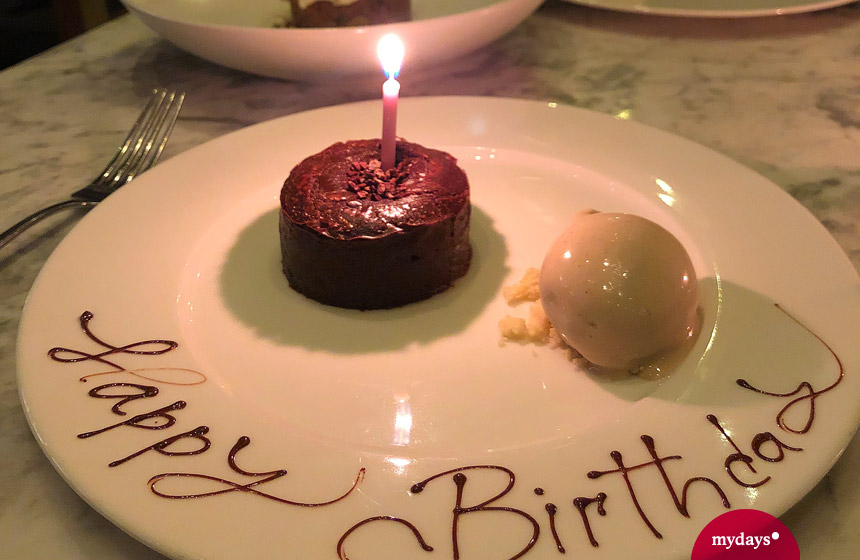 Dessert mit Kerze und Happy birthday Schriftzug