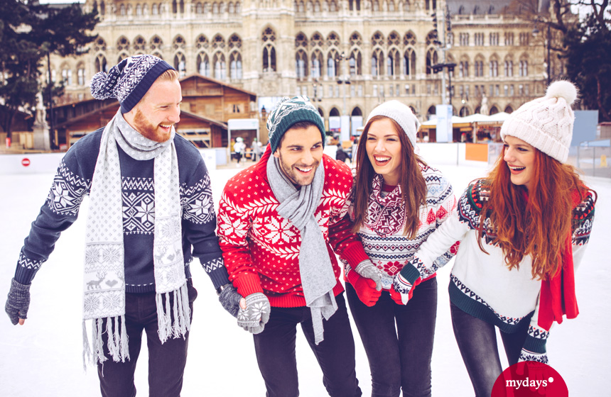 Städtereisen im Winter. Wien, vier Freunde beim Schlittschuhlaufen, Schlittschuhbahn
