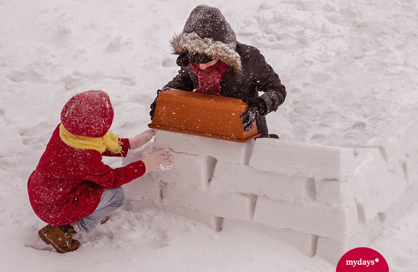 Ein Kind und eine Frau bauen eine Schneebar selber