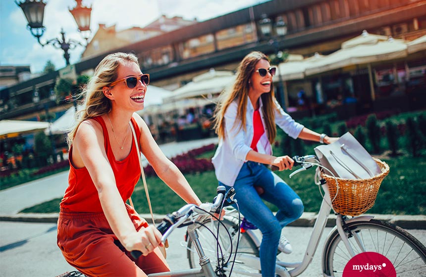 Mädchen erkunden Stadt mit dem Fahrrad.