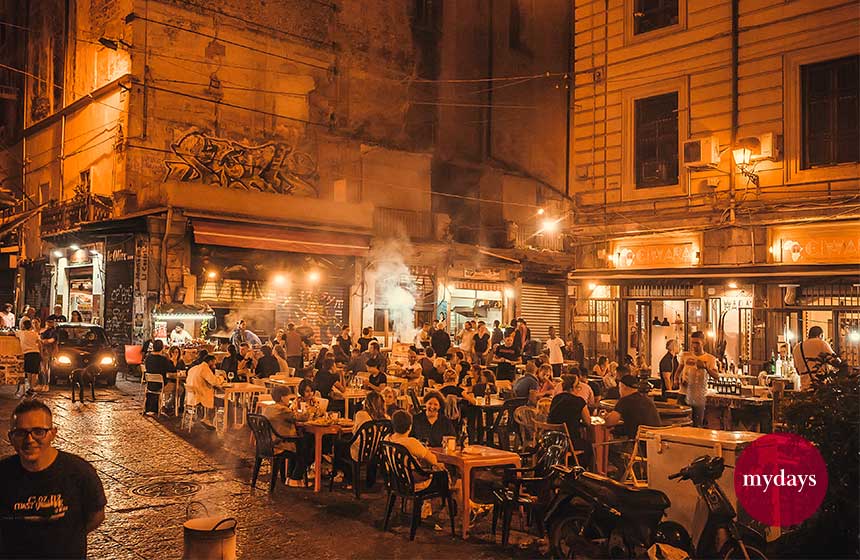 Menschen an Tischen des nächtlichen Stadtmarkts am essen und trinken