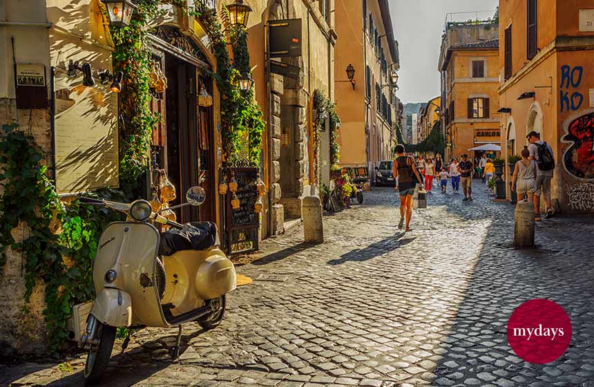 Menschen und Gebäude in einer Gasse von Trastevere