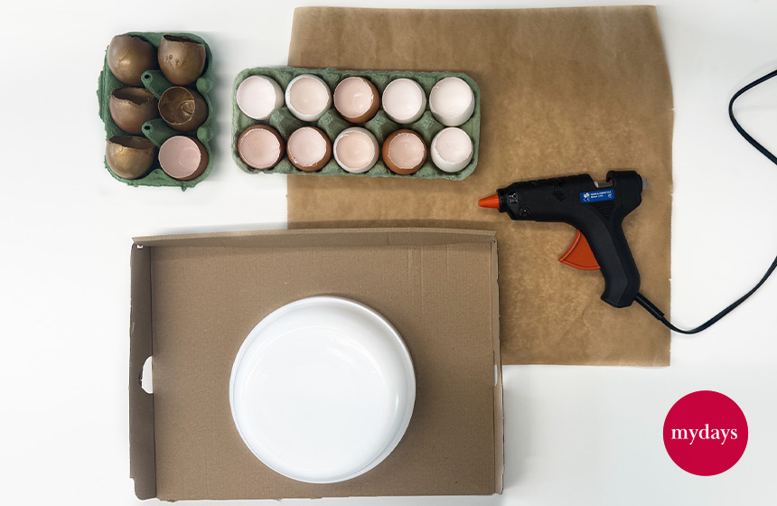 Für den DIY Osterkranz steht alles bereit zum Zusammenkleben: Gefärbte Eierschalen, Heißklebepistole, Vorlage.