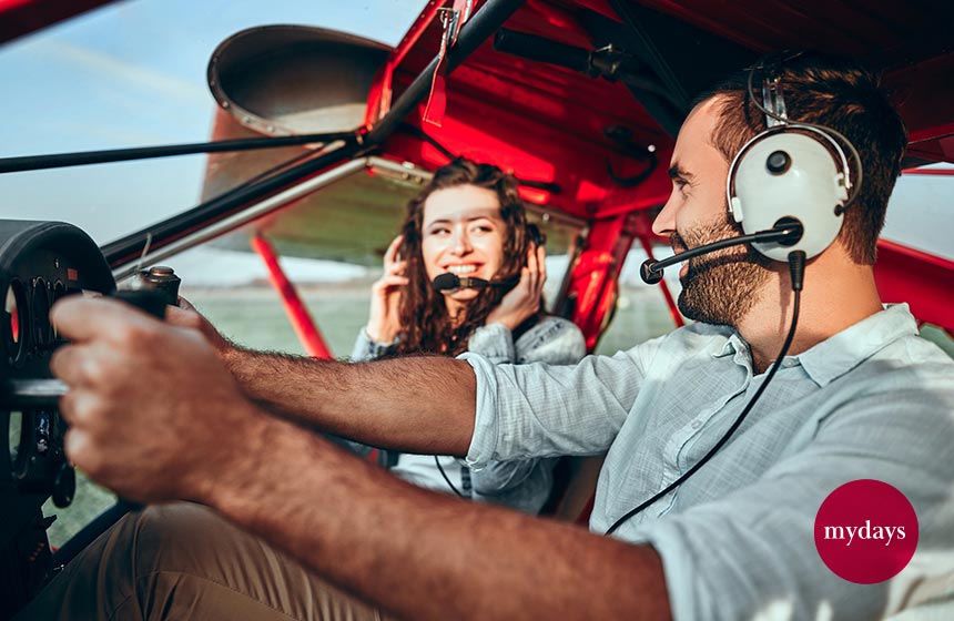 Zwei Freunde im Cockpit eines roten Flugzeugs am Tag der Freundschaft